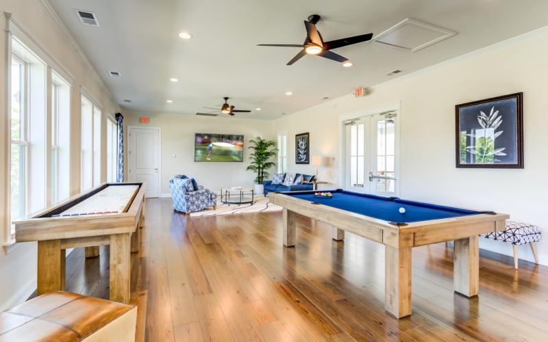a room with a pool table and chairs